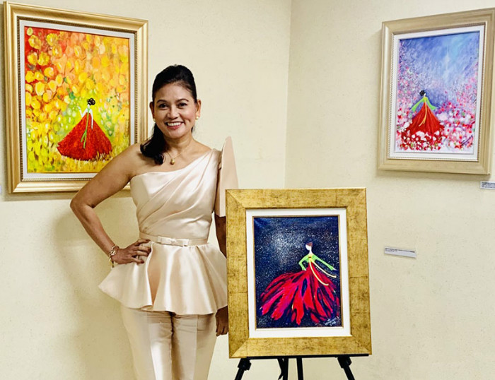 Ana Algabre-Hernandez, the wife of former Philippine Ambassador to Korea Raul Hernandez, poses for a photo with her painting “The Joy of Spring” at the Philippine Embassy in Seoul’s Yongsan-gu District.